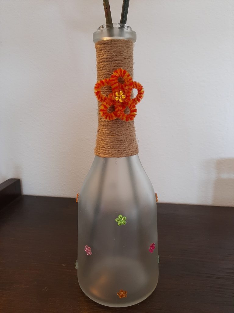 Bottle turned into vase with jute ribbon and rhinestones